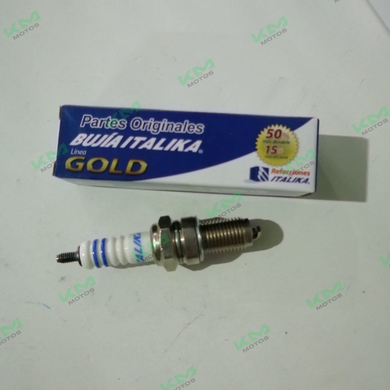 Bujía de motor Italika Gold GDR8EA para motos deportivas y clásicas, en color grafito, instalada en un motor de motocicleta.