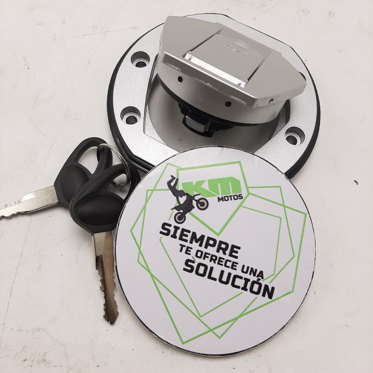 Tapón de tanque para NS200 de KM Motos, mostrando el componente de plástico y su cierre para protección del combustible.